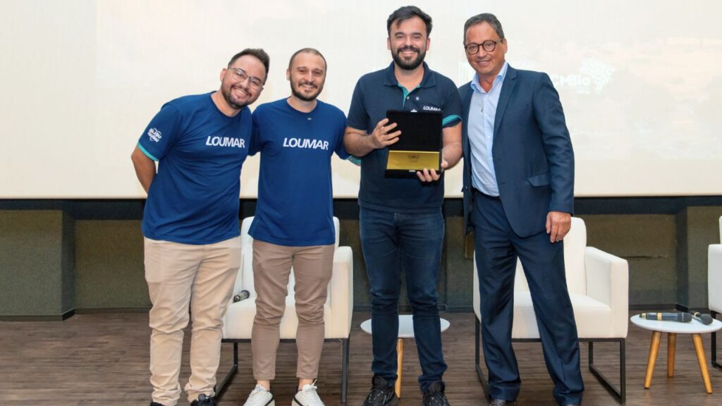 André Vinícius, Elmo Junior e Garon Piceli, representando o Grupo Loumar, recebem homenagem das mãos de Mário Macedo, CEO da Urbia Cataratas.